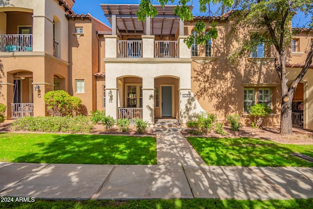 view of front of house featuring a front yard and a balcony