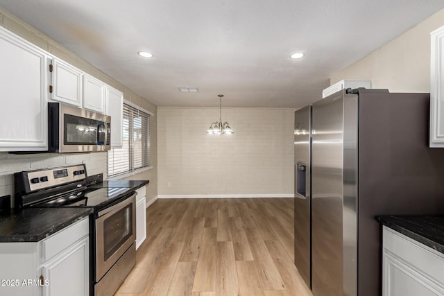915 E Commonwealth Pl, Chandler, AZ 85225 - kitchen featuring stainless steel appliances, white cabinets, light wood finished floors, dark countertops, and a chandelier