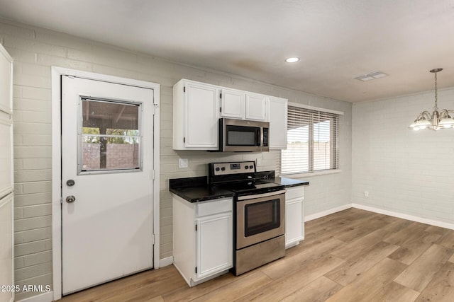 915 E Commonwealth Pl, Chandler, AZ 85225 - kitchen featuring stainless steel appliances, dark countertops, white cabinetry, light wood-style floors, and brick wall