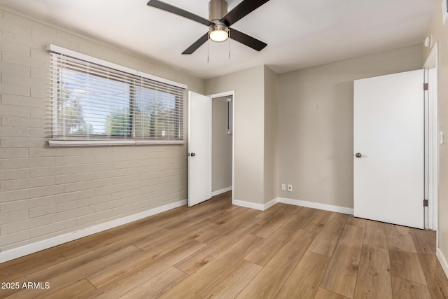 915 E Commonwealth Pl, Chandler, AZ 85225 - unfurnished bedroom with light wood finished floors, brick wall, and ceiling fan