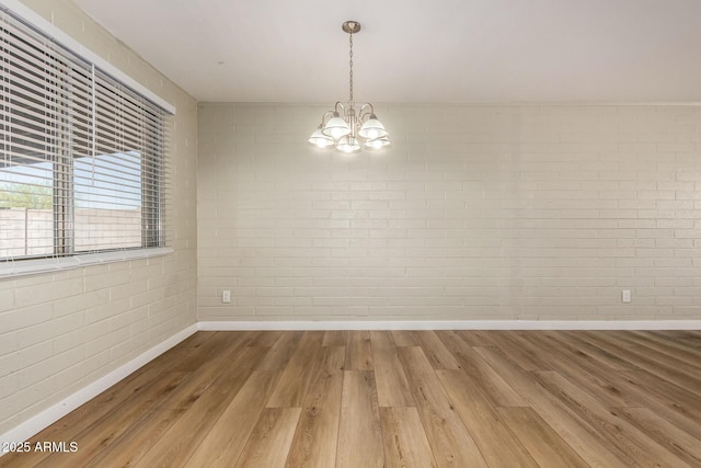 915 E Commonwealth Pl, Chandler, AZ 85225 - empty room with wood finished floors, a chandelier, and brick wall