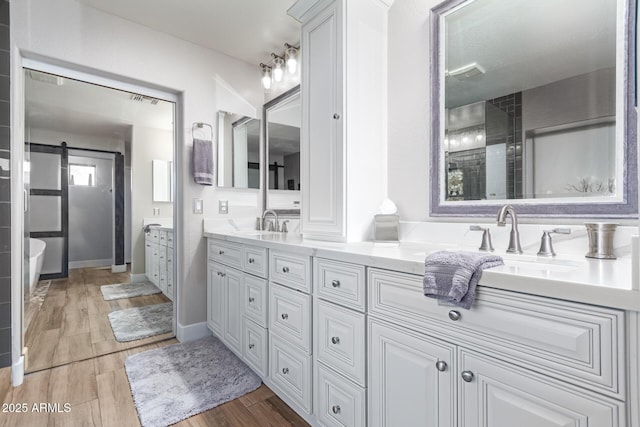 bathroom with a shower with shower door and vanity