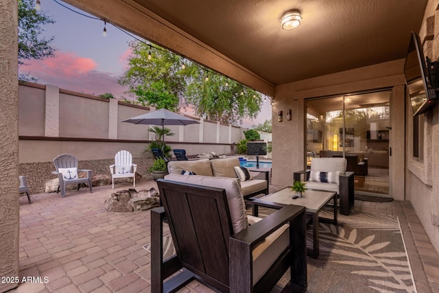 patio terrace at dusk with an outdoor hangout area and a swimming pool