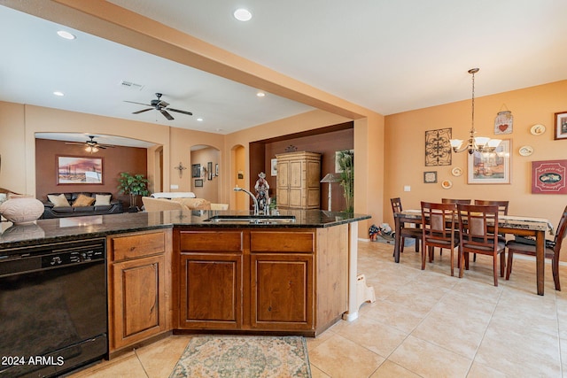 kitchen with dark stone counters, pendant lighting, ceiling fan with notable chandelier, sink, and black dishwasher