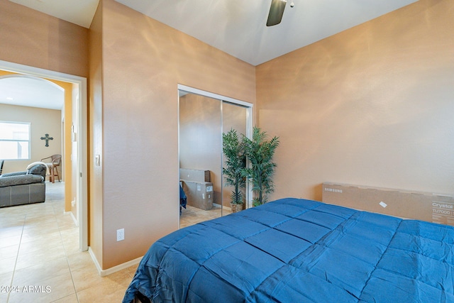 bedroom with light tile patterned floors, ceiling fan, and a closet