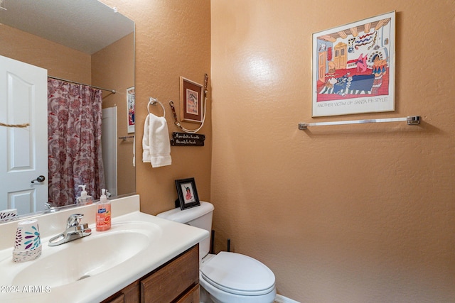 bathroom with vanity, toilet, and walk in shower