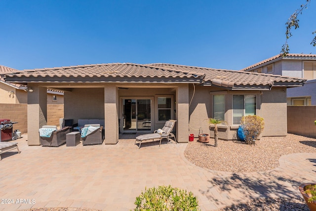 rear view of house featuring an outdoor living space and a patio