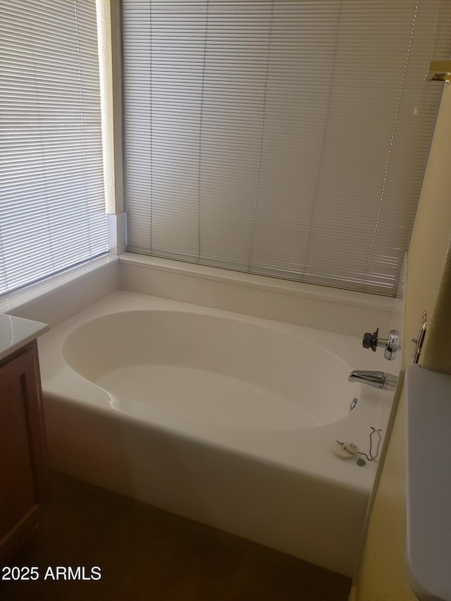 bathroom with vanity and a bath