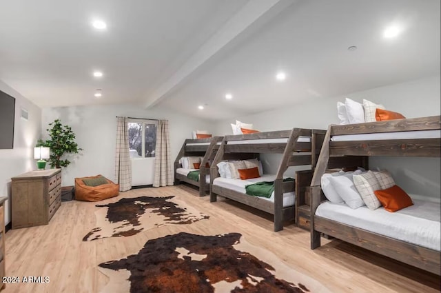 bedroom featuring lofted ceiling with beams and light hardwood / wood-style flooring