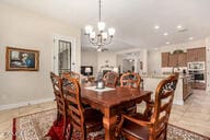 dining area with light tile patterned floors and a notable chandelier