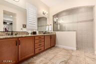 bathroom with a tile shower and vanity