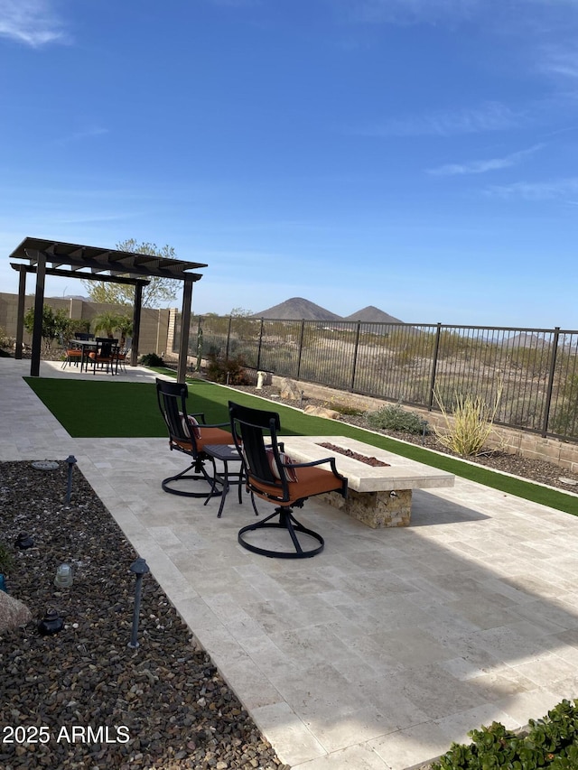 view of patio / terrace with a pergola, a mountain view, and a fire pit