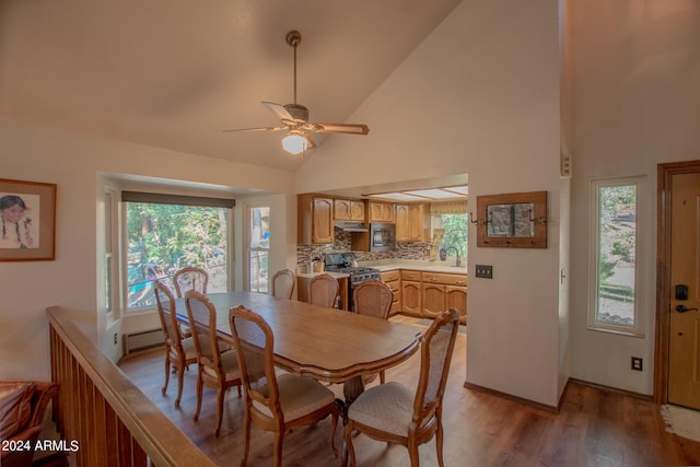 dining room featuring sink, high vaulted ceiling, light wood-type flooring, and ceiling fan