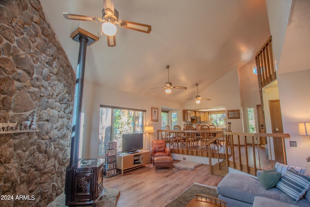 living room featuring a wood stove, a wealth of natural light, and light wood-type flooring