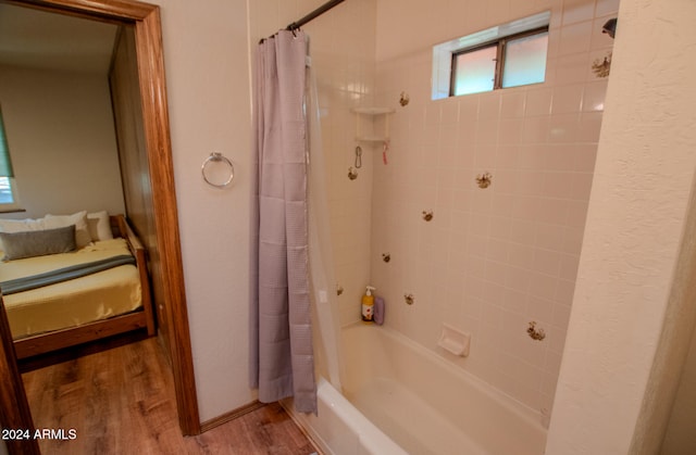 bathroom featuring hardwood / wood-style flooring and shower / bathtub combination with curtain