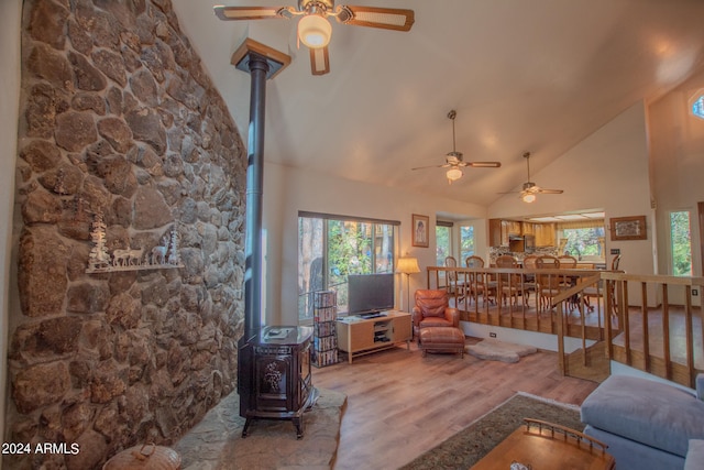 living room featuring a wealth of natural light, wood-type flooring, and a wood stove