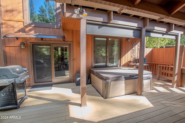 wooden deck featuring grilling area and a covered hot tub