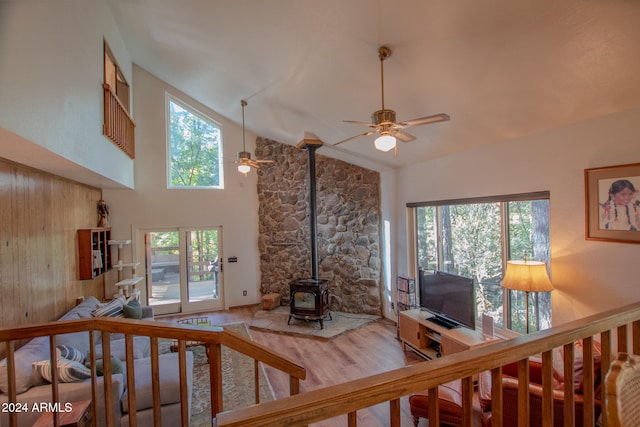 living room with a wood stove, hardwood / wood-style floors, high vaulted ceiling, and a wealth of natural light