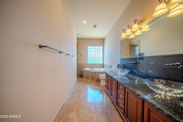 bathroom featuring double vanity, a bath, marble finish floor, and a sink