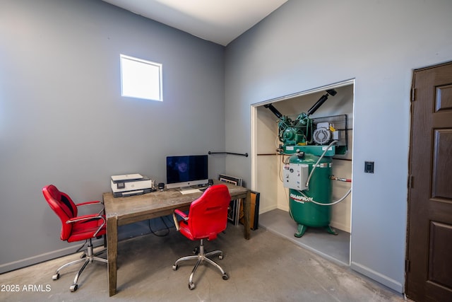 office with unfinished concrete floors and baseboards