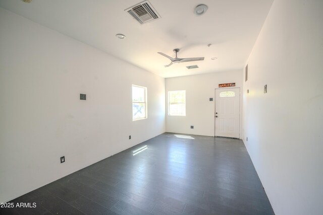 spare room with visible vents, ceiling fan, and dark wood finished floors