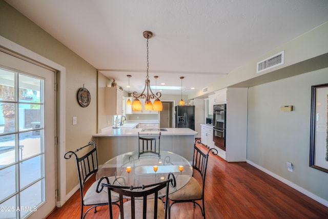 dining space with visible vents, dark wood finished floors, and baseboards