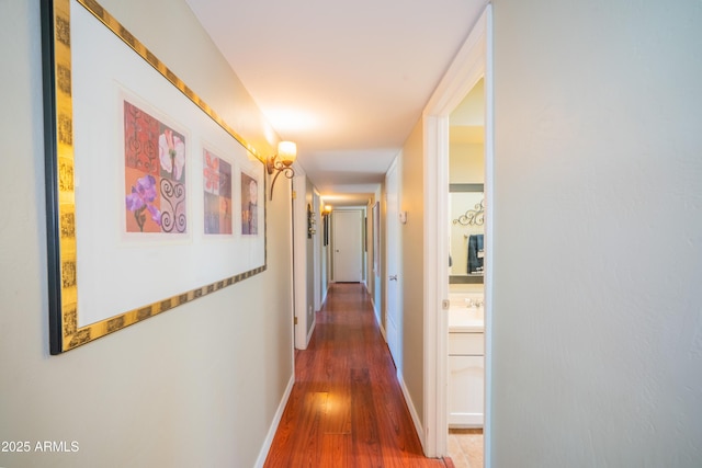 hallway featuring wood finished floors and baseboards