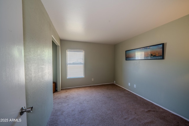 unfurnished room featuring baseboards and carpet floors