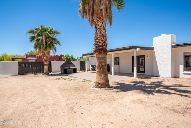back of property with a patio, fence, and stucco siding