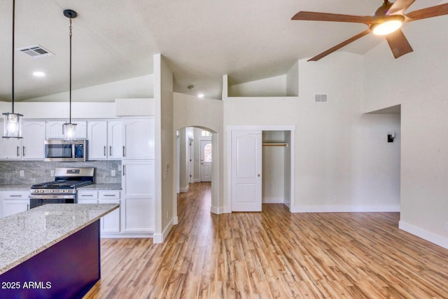 kitchen with stainless steel appliances, white cabinetry, and decorative light fixtures