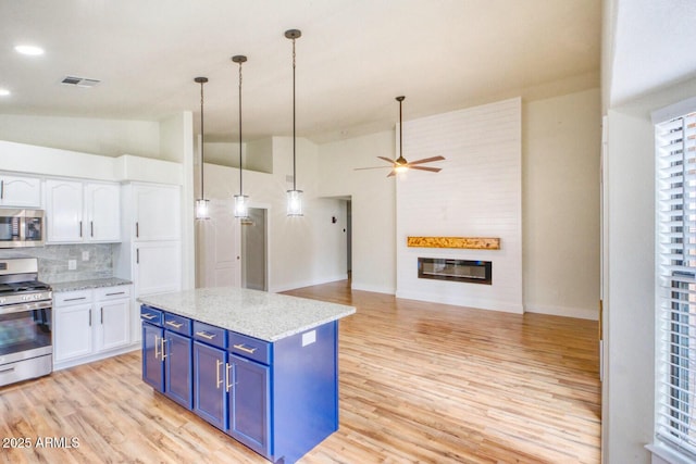 kitchen with decorative light fixtures, white cabinetry, stainless steel appliances, decorative backsplash, and blue cabinets