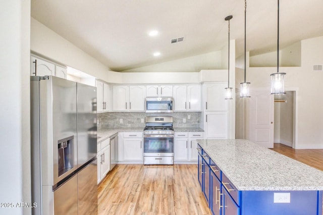 kitchen with hanging light fixtures, appliances with stainless steel finishes, tasteful backsplash, blue cabinets, and lofted ceiling