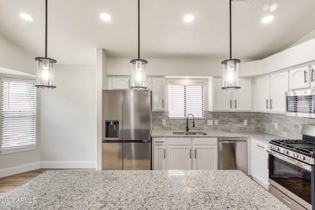 kitchen with sink, decorative light fixtures, white cabinets, and appliances with stainless steel finishes