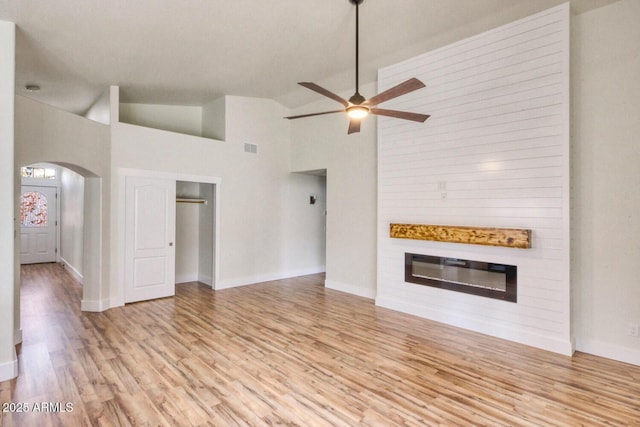 unfurnished living room with light hardwood / wood-style floors, high vaulted ceiling, and ceiling fan