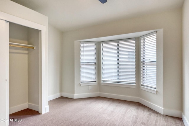 unfurnished bedroom featuring a closet and light colored carpet