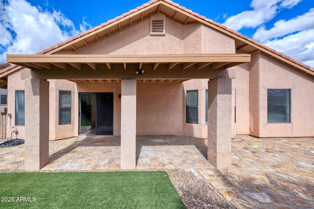 back of property with a patio