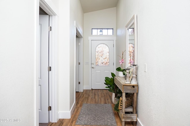 doorway to outside with hardwood / wood-style flooring and high vaulted ceiling