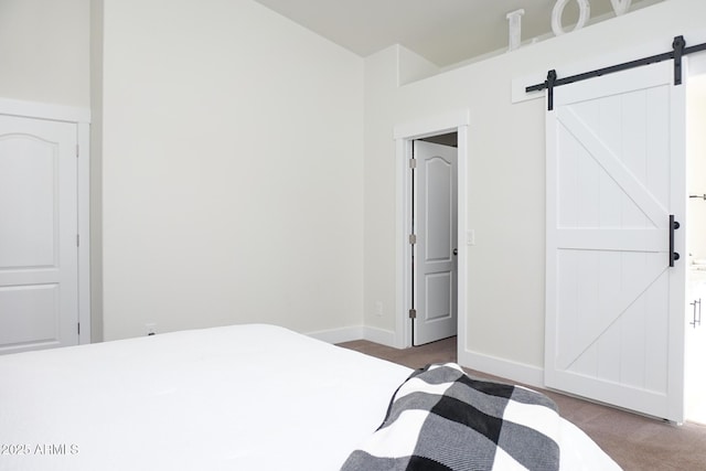 bedroom with a barn door and carpet floors