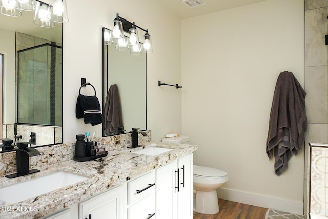 bathroom featuring hardwood / wood-style floors, toilet, walk in shower, and vanity