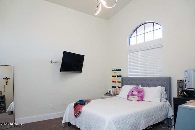 bedroom featuring high vaulted ceiling and dark carpet