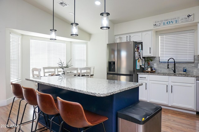 kitchen featuring decorative light fixtures, sink, tasteful backsplash, and stainless steel fridge