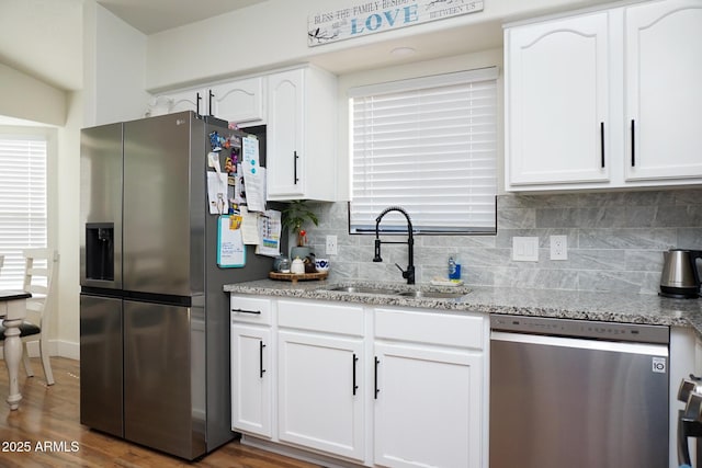 kitchen featuring sink, white cabinets, light stone counters, dark hardwood / wood-style floors, and stainless steel appliances