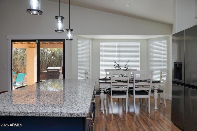 dining space featuring dark wood-type flooring and vaulted ceiling