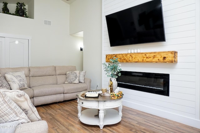 living room featuring hardwood / wood-style flooring and a high ceiling