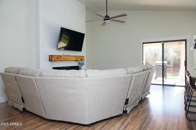 living room with ceiling fan, dark wood-type flooring, and lofted ceiling