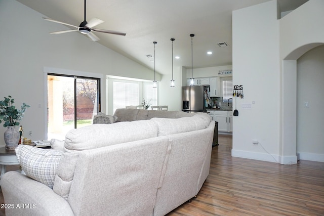 living room with sink, dark wood-type flooring, vaulted ceiling, and ceiling fan