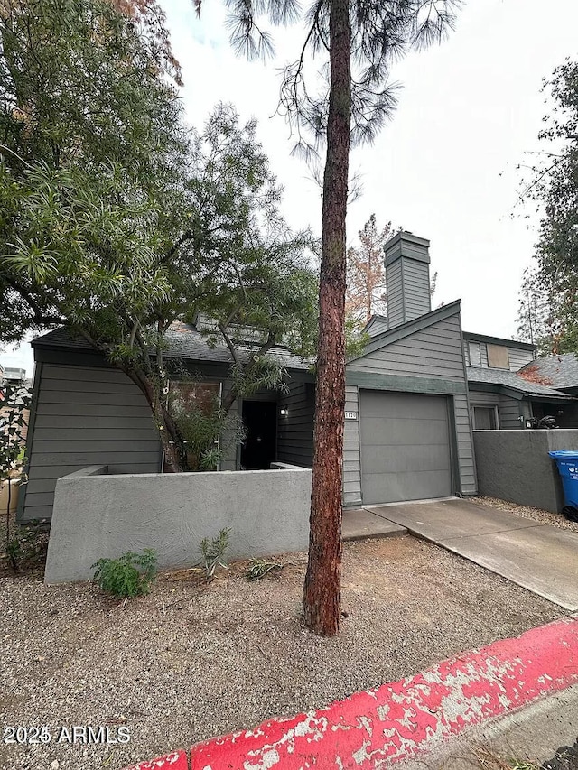 14002 N 49th Ave Unit 1120, Glendale, AZ 85306 - mid-century home featuring driveway, a chimney, and an attached garage
