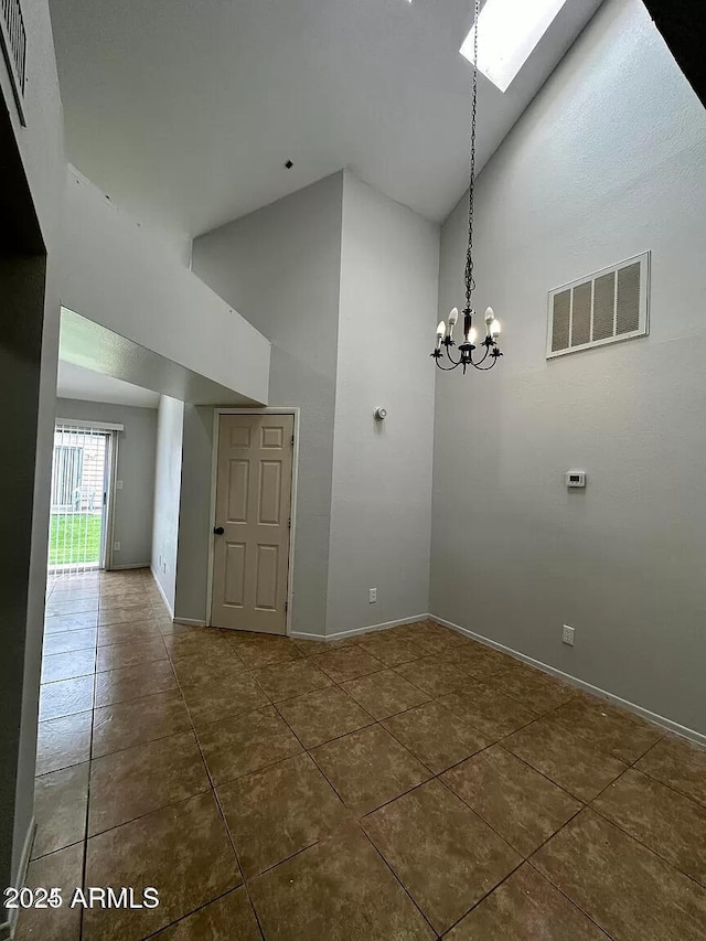 14002 N 49th Ave Unit 1120, Glendale, AZ 85306 - tiled spare room with high vaulted ceiling, baseboards, a chandelier, and a skylight