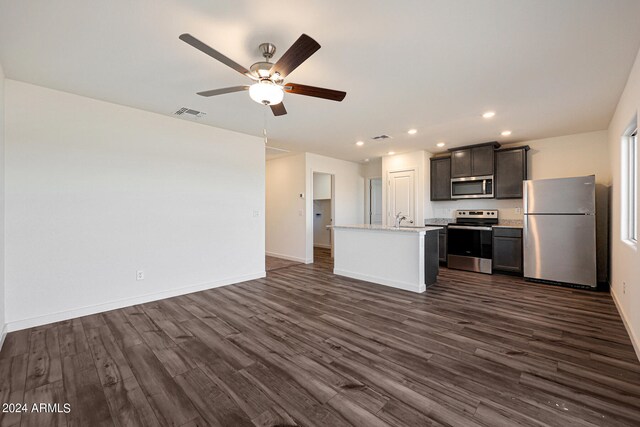 kitchen featuring a center island with sink, dark hardwood / wood-style floors, ceiling fan, and appliances with stainless steel finishes