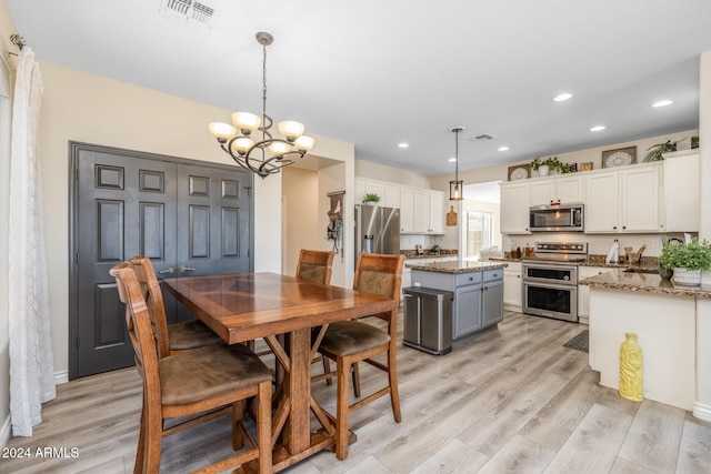 dining room featuring an inviting chandelier and light hardwood / wood-style flooring